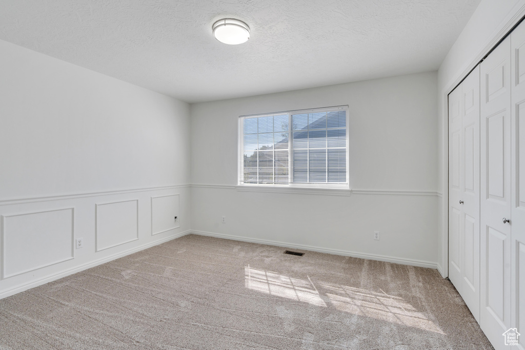 Unfurnished bedroom featuring a closet and light carpet