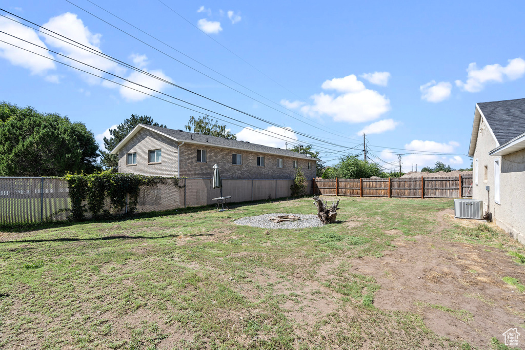 View of yard with cooling unit and a fire pit