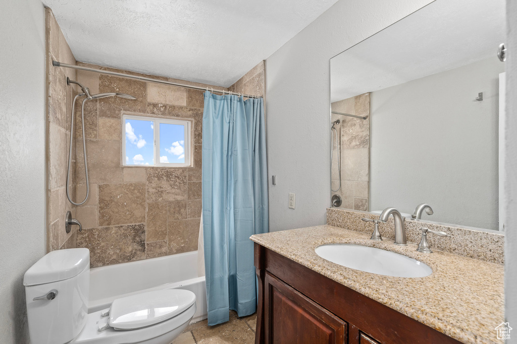 Full bathroom featuring tile patterned floors, vanity, shower / tub combo, and toilet