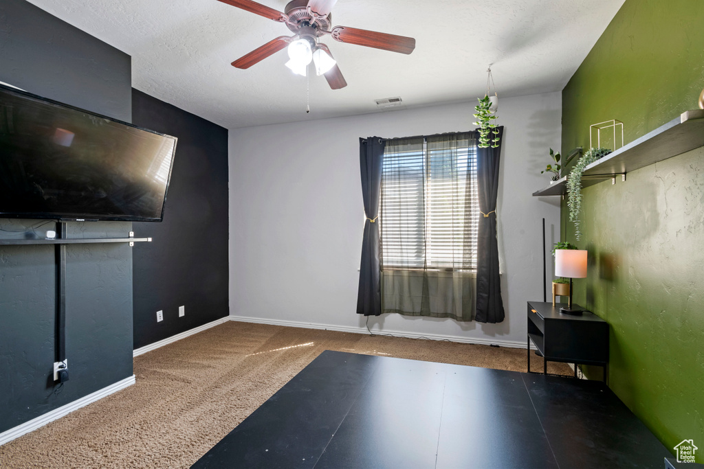 Interior space featuring ceiling fan and carpet floors