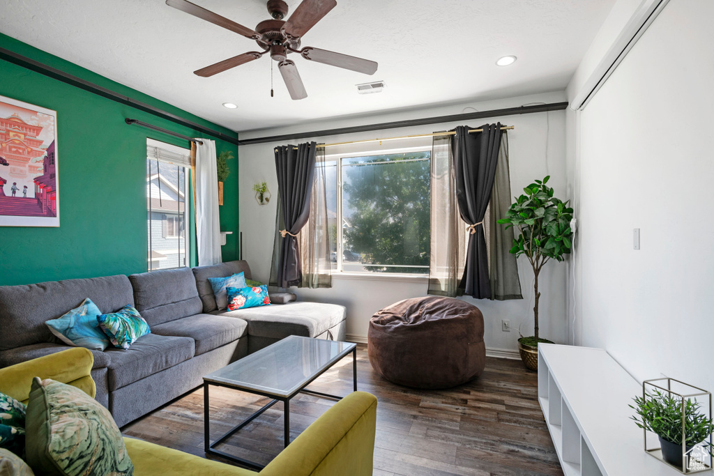 Living room with ceiling fan and dark hardwood / wood-style flooring