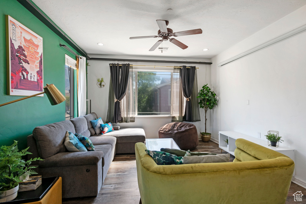 Living room featuring wood-type flooring and ceiling fan