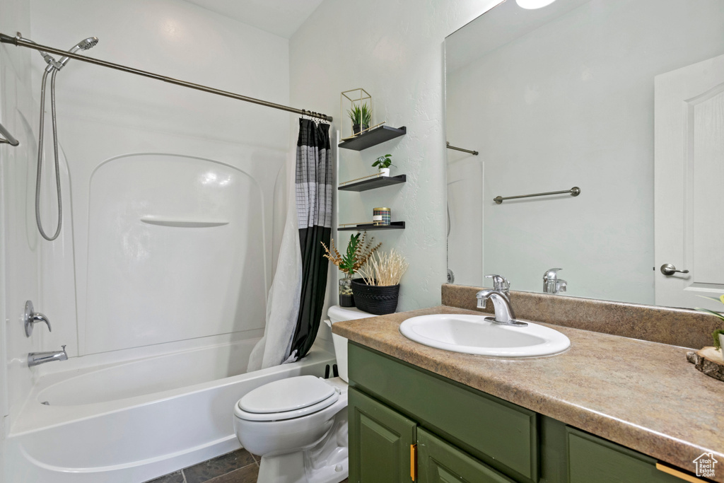 Full bathroom featuring tile patterned flooring, vanity, toilet, and shower / tub combo with curtain