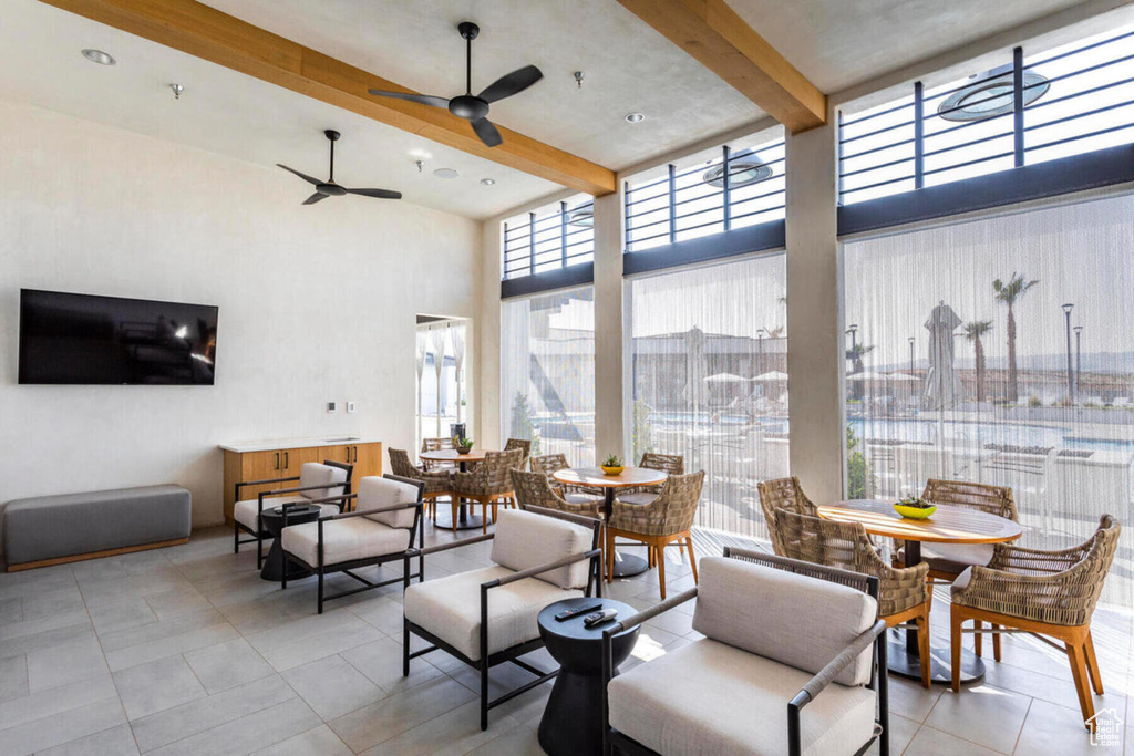 Interior space with a towering ceiling, beam ceiling, and ceiling fan