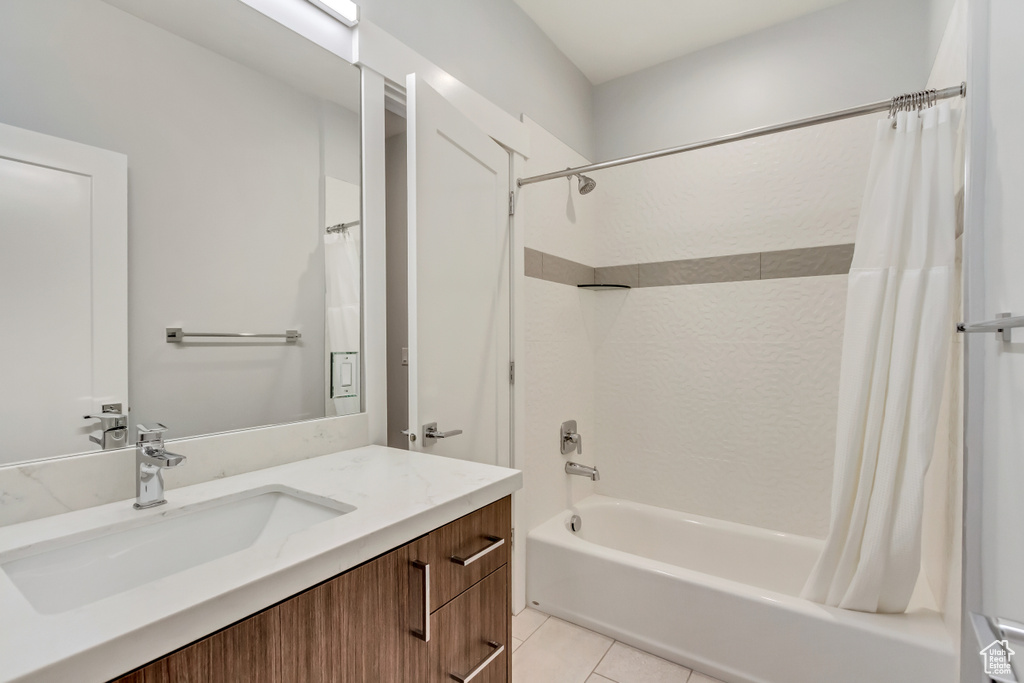 Bathroom with tile patterned flooring, vanity, and shower / bathtub combination with curtain