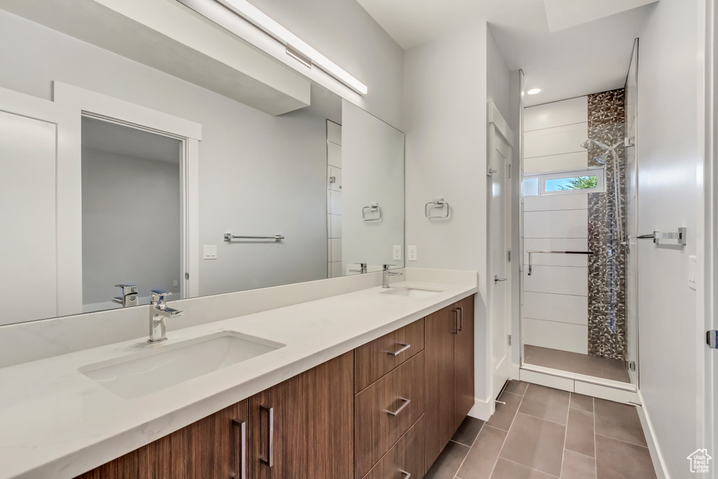 Bathroom featuring tile patterned flooring, a shower, and vanity