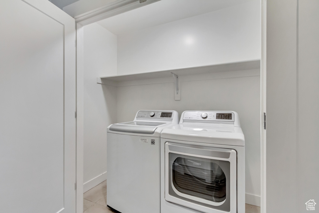 Laundry room featuring independent washer and dryer and light tile patterned floors