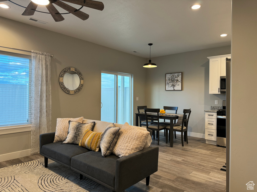 Living room with ceiling fan and light hardwood / wood-style floors