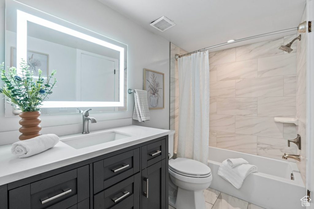 Full bathroom with shower / bath combo, tile patterned flooring, toilet, and vanity