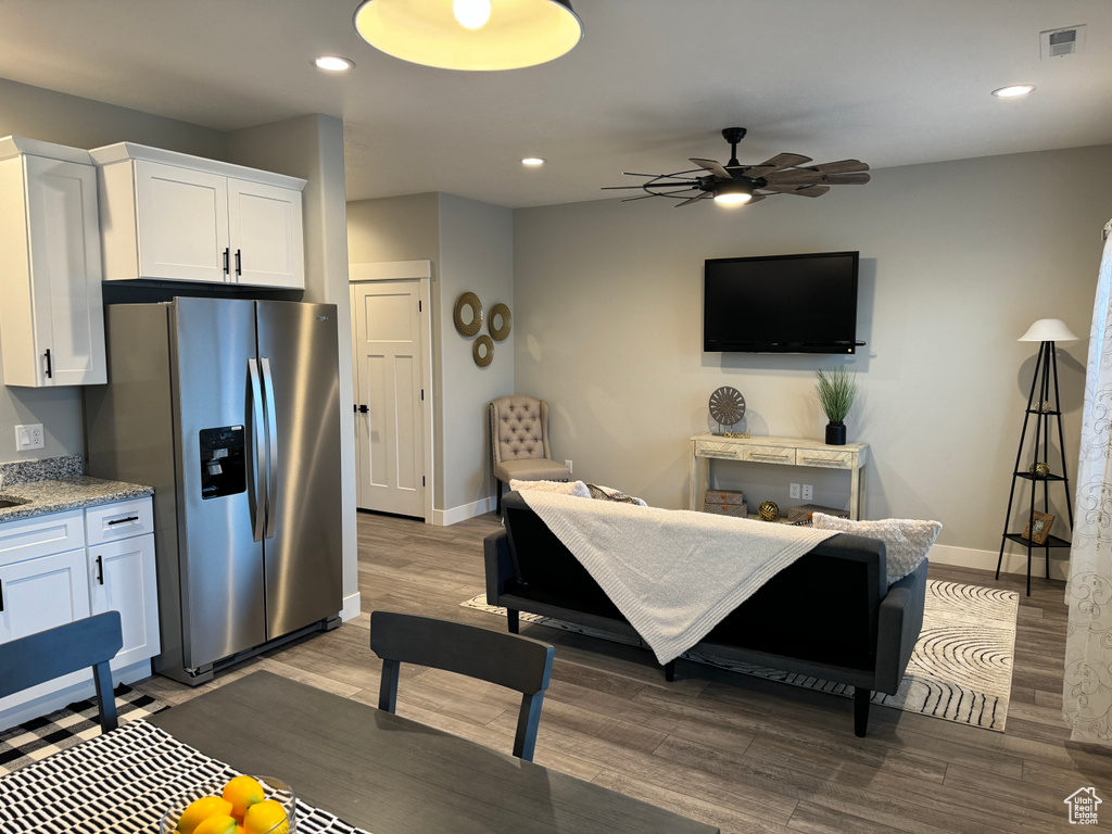 Living room featuring dark wood-type flooring and ceiling fan