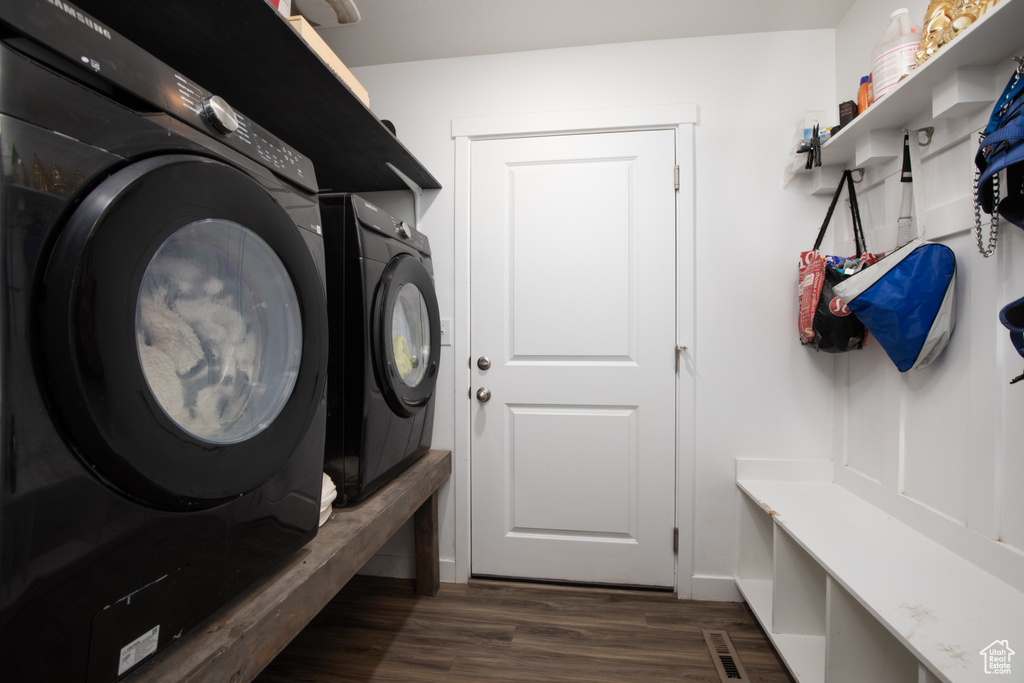 Mudroom with dark wood-type flooring and washer and dryer