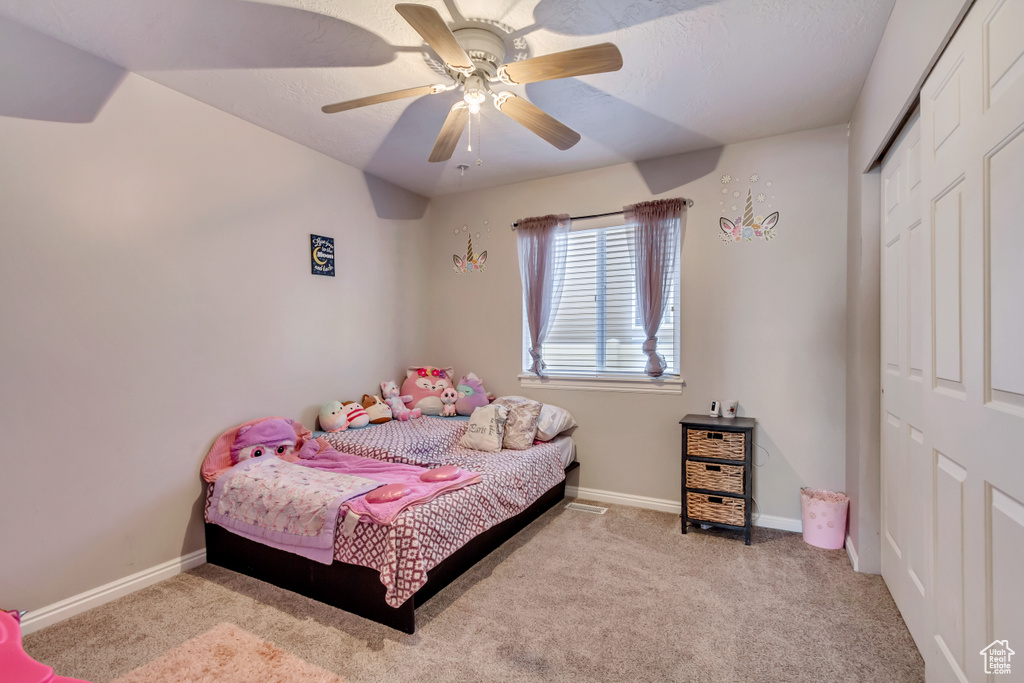 Bedroom featuring ceiling fan, a closet, and carpet floors