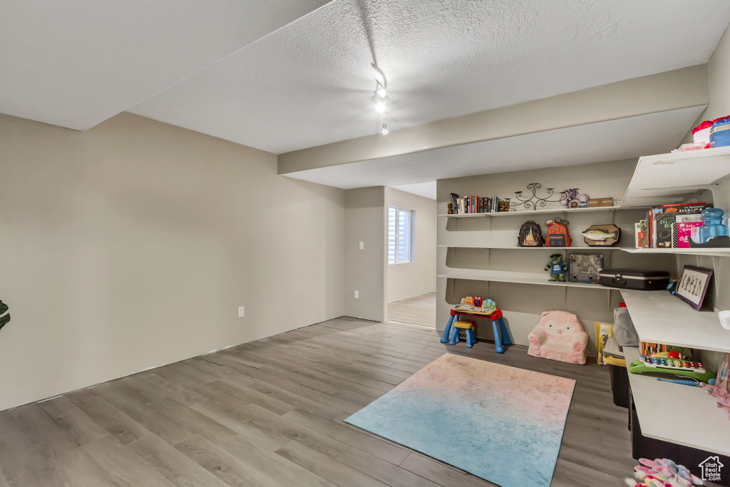 Game room with light hardwood / wood-style flooring and a textured ceiling