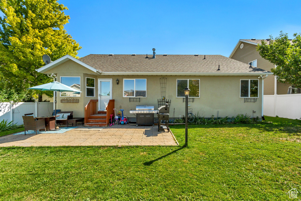 Rear view of property featuring a patio area and a yard