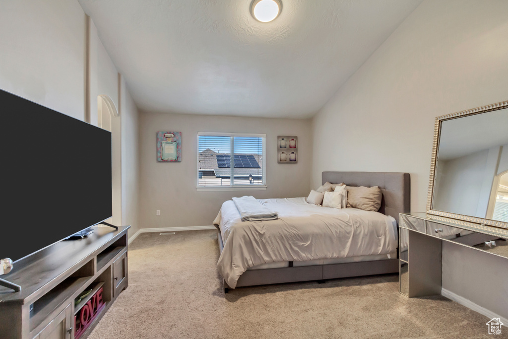 Carpeted bedroom featuring lofted ceiling