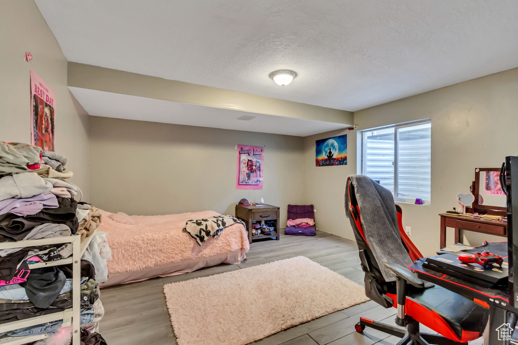 Bedroom featuring a textured ceiling and light hardwood / wood-style floors