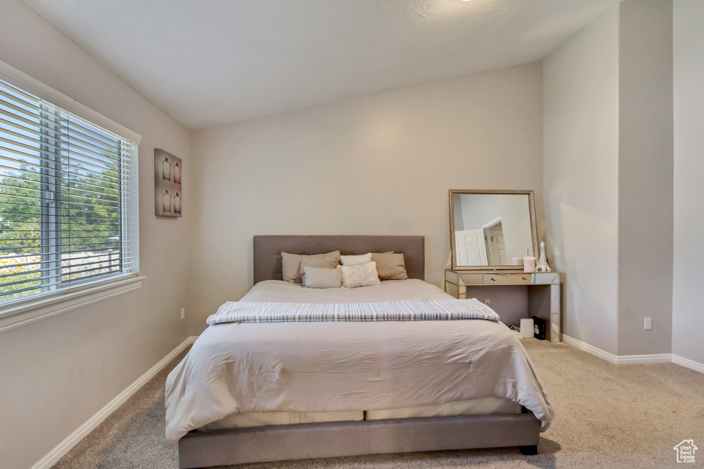 Carpeted bedroom featuring lofted ceiling