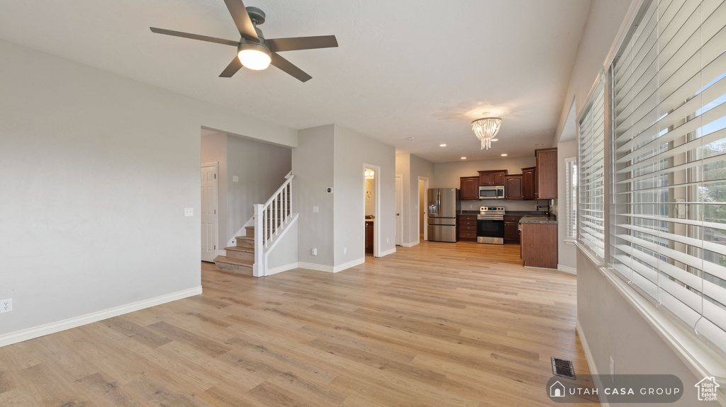 Unfurnished living room featuring light wood-type flooring and ceiling fan