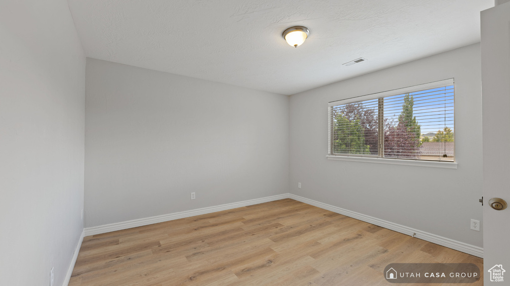 Empty room with light hardwood / wood-style floors