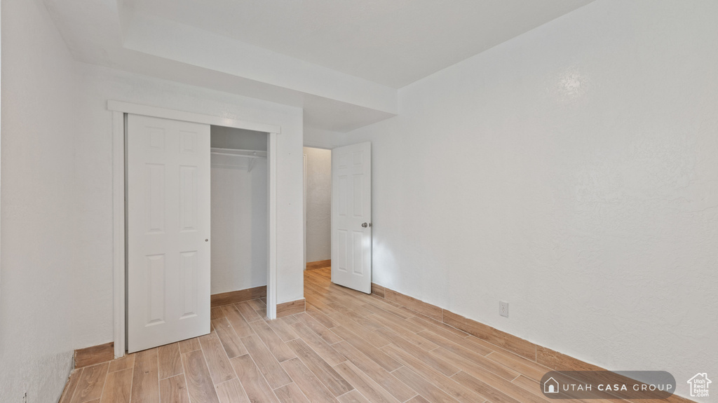 Unfurnished bedroom featuring a closet and light wood-type flooring