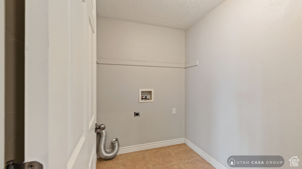 Laundry area featuring washer hookup, light tile patterned floors, and hookup for an electric dryer