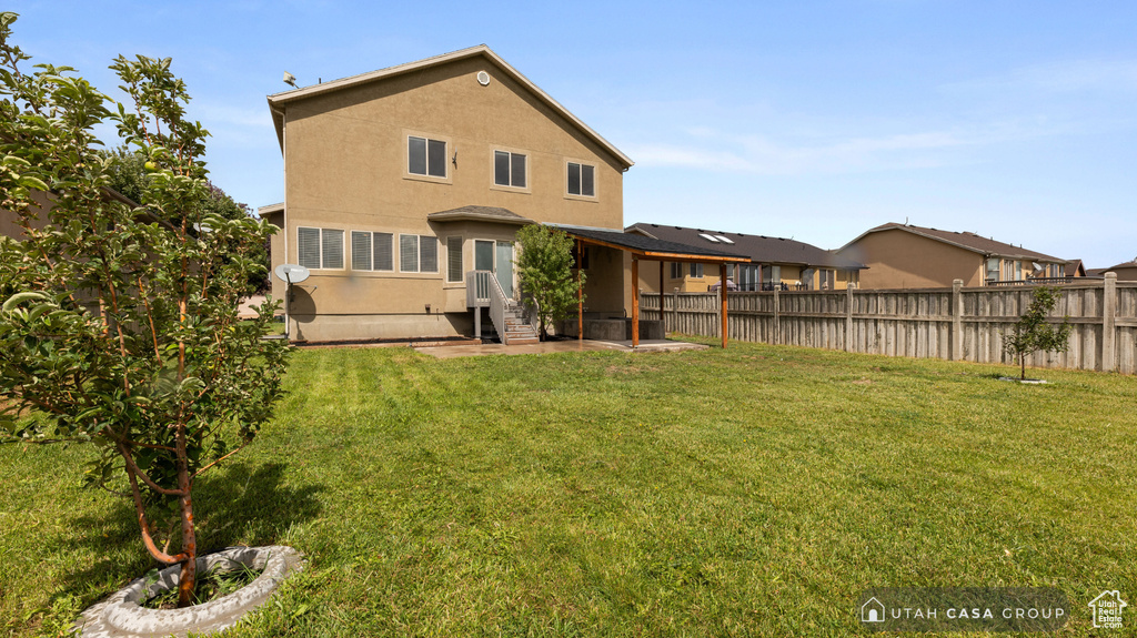 Rear view of house featuring a patio area and a yard