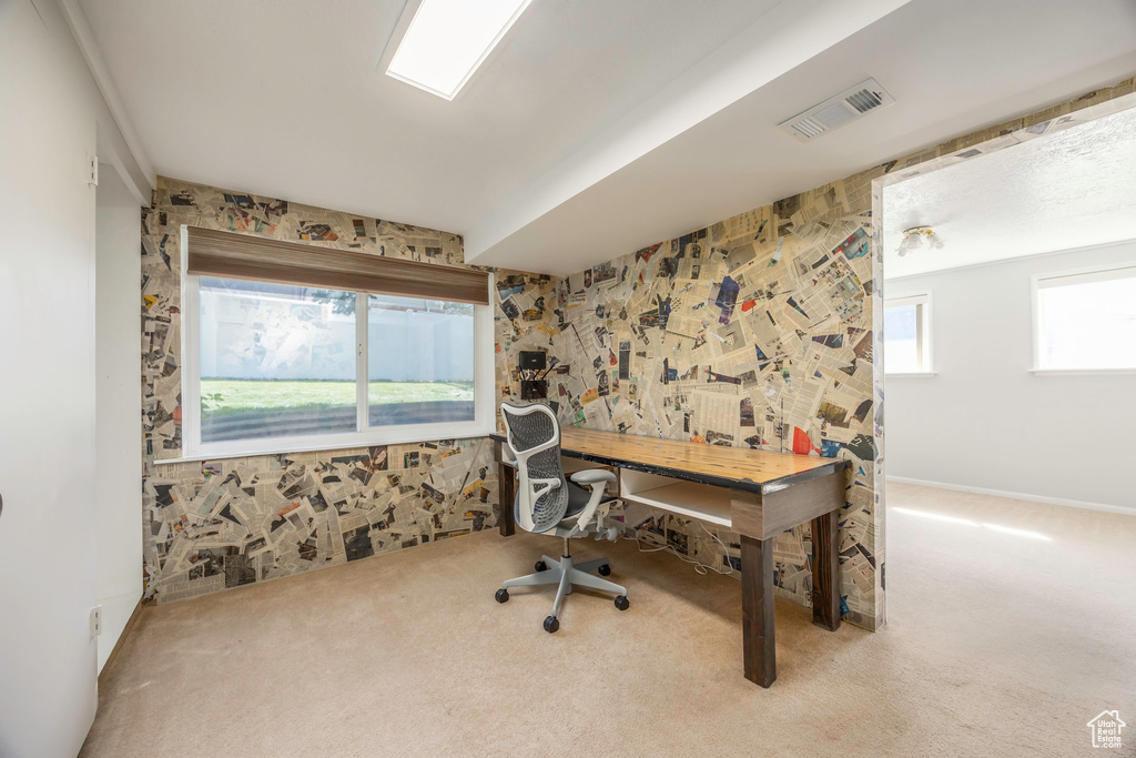 Carpeted office featuring a healthy amount of sunlight