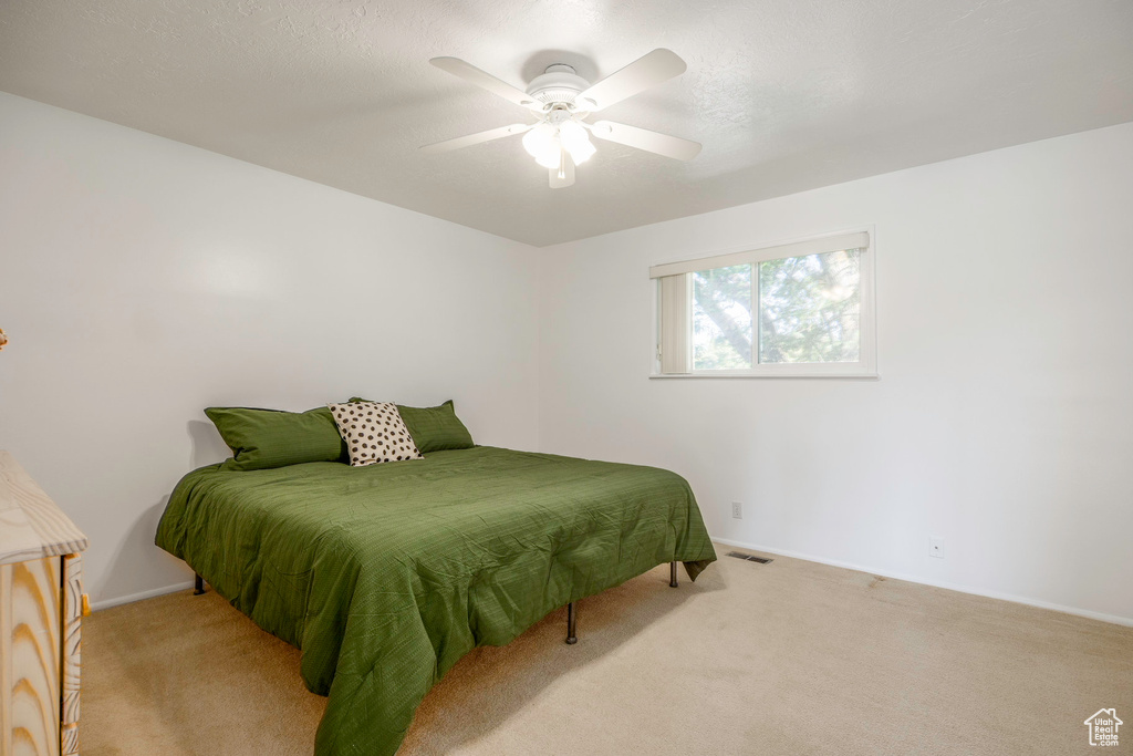 Carpeted bedroom with ceiling fan