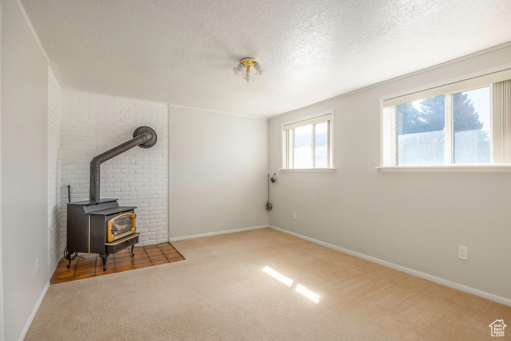 Interior space featuring a wood stove and a textured ceiling