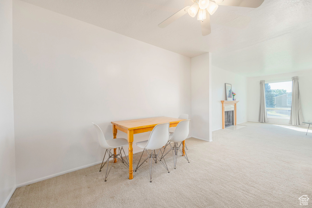 Carpeted dining area with ceiling fan