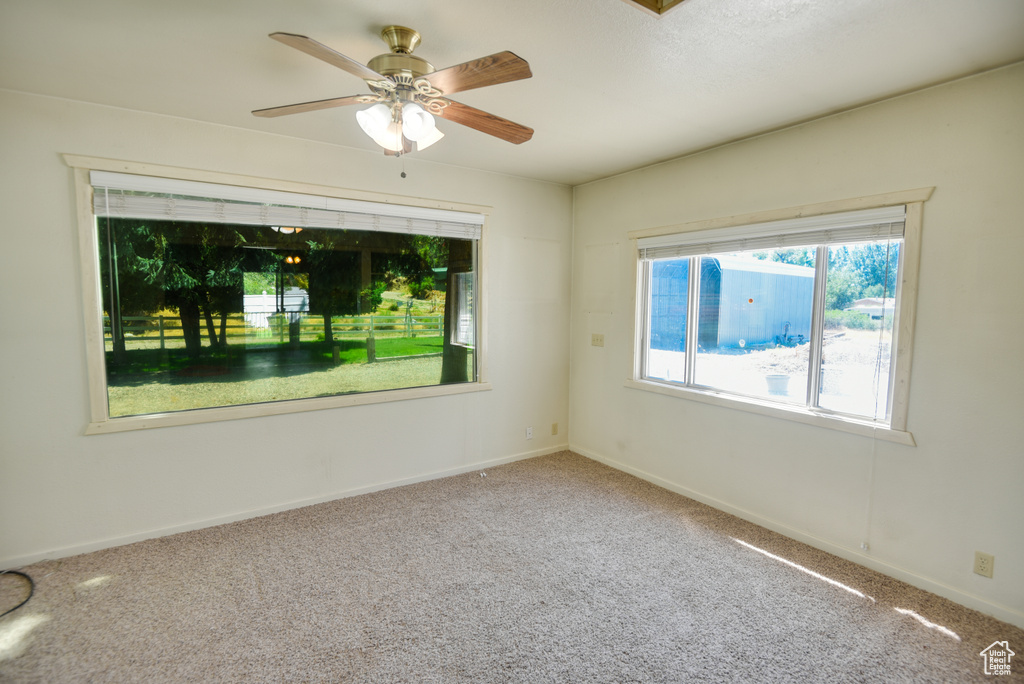 Carpeted spare room featuring ceiling fan
