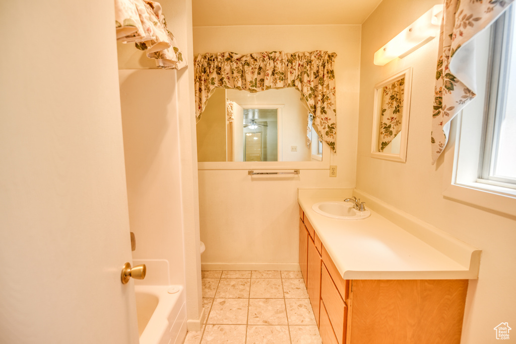 Full bathroom featuring tile patterned flooring, toilet, shower with separate bathtub, ceiling fan, and vanity