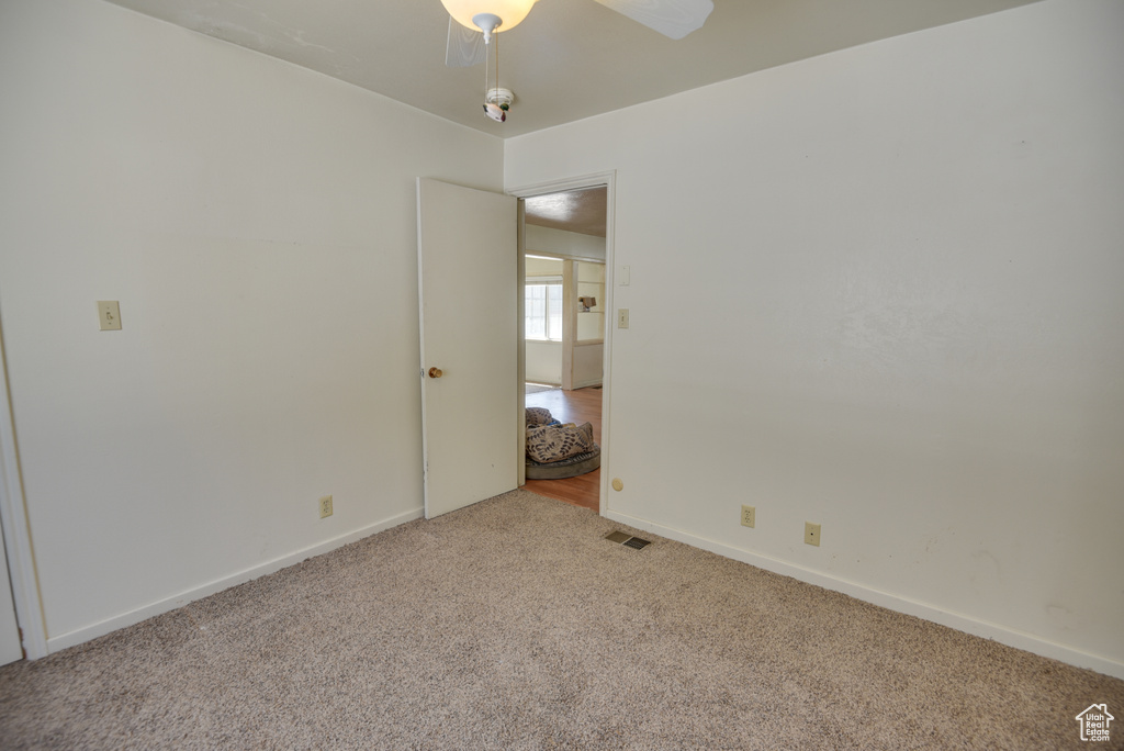 Spare room featuring light carpet and ceiling fan