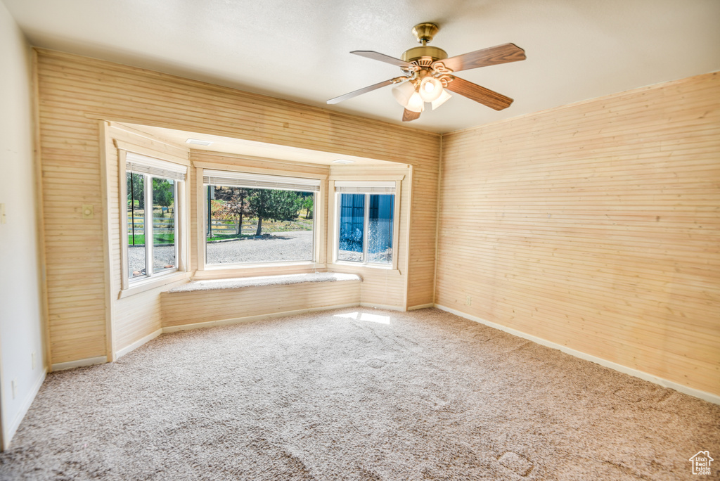 Empty room featuring ceiling fan and carpet flooring