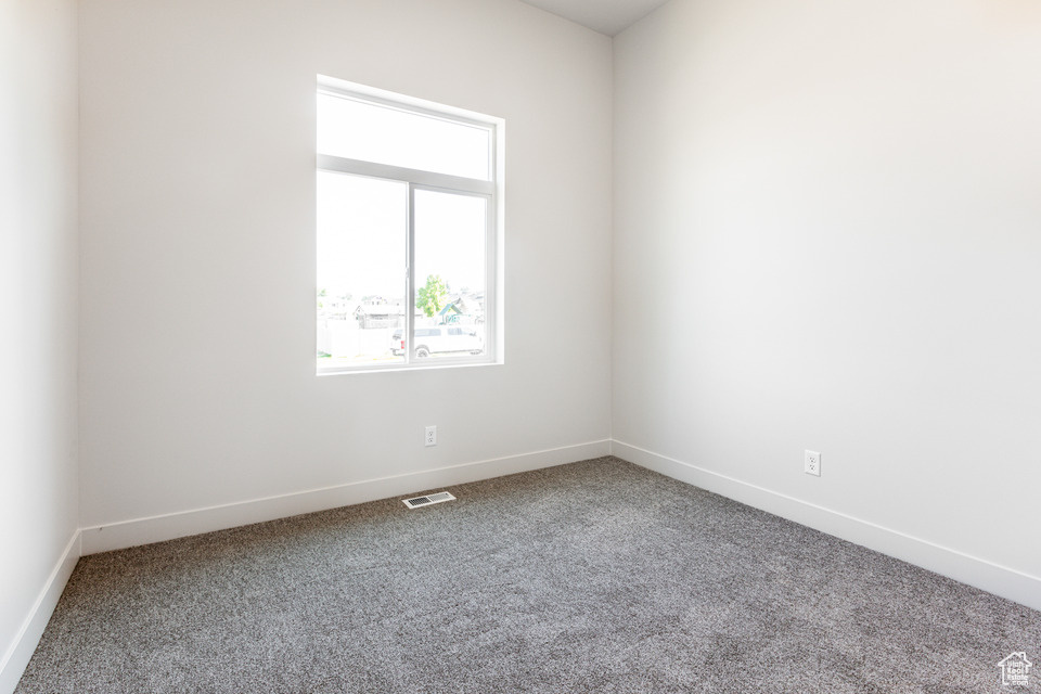 Carpeted empty room featuring plenty of natural light