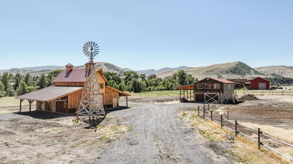 Exterior space with a mountain view, an outbuilding, and a rural view