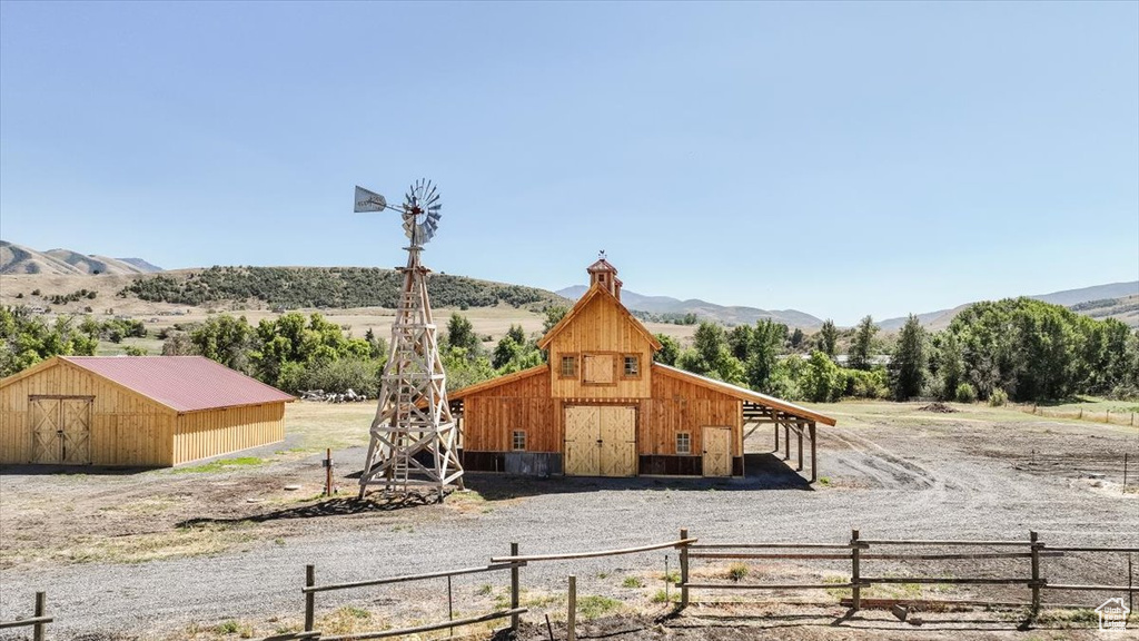 Exterior space featuring a rural view, an outdoor structure, and a mountain view