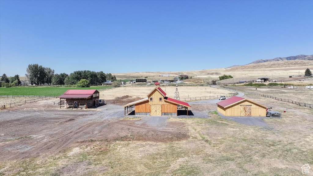 Exterior space featuring a rural view, an outdoor structure, and a mountain view