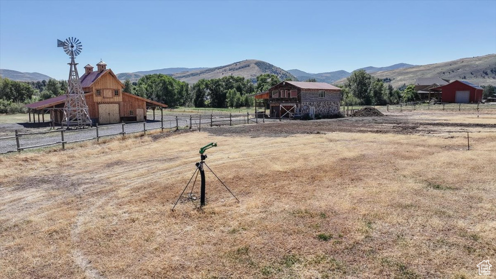 View of yard featuring a mountain view, an outdoor structure, and a rural view