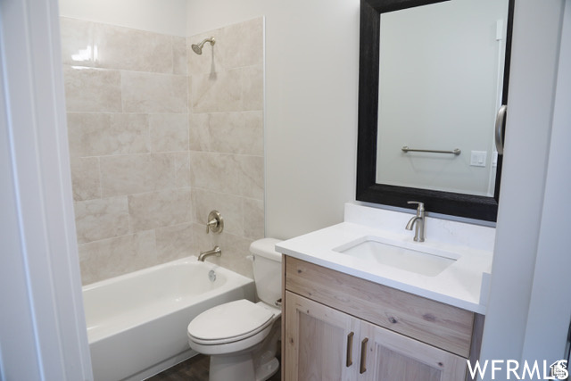 Full bathroom with tiled shower / bath, toilet, and vanity