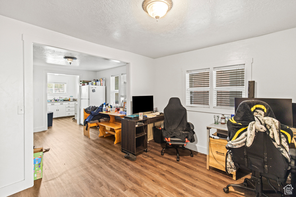 Office with hardwood / wood-style flooring and a textured ceiling