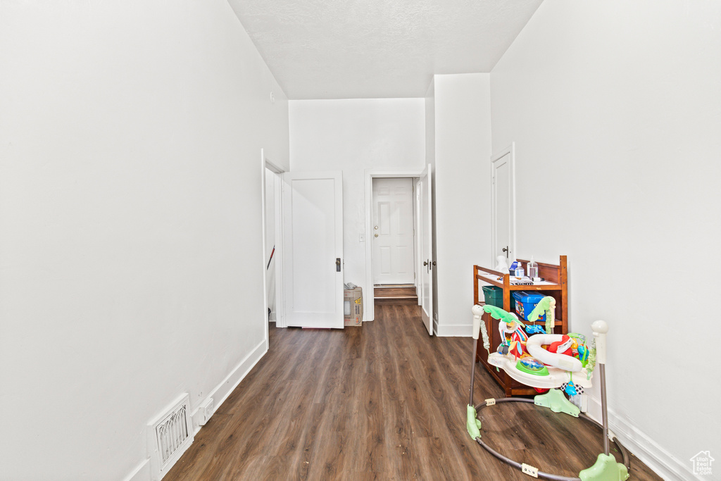 Playroom with a textured ceiling and dark hardwood / wood-style floors