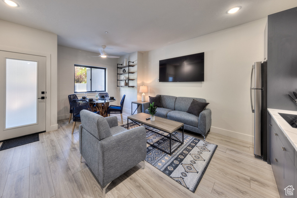 Living room with ceiling fan and light wood-type flooring