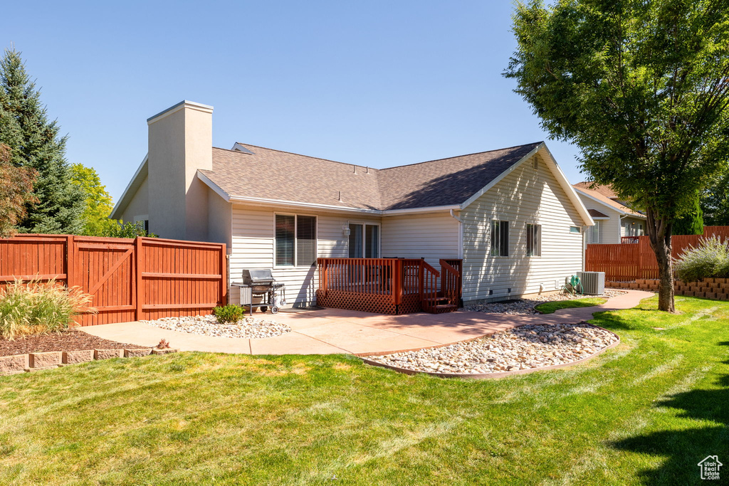 Rear view of property featuring a patio area, a yard, and central air condition unit