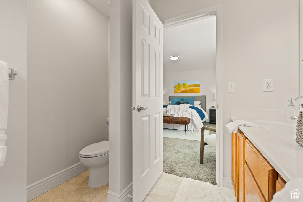 Bathroom with vanity, toilet, and tile patterned floors