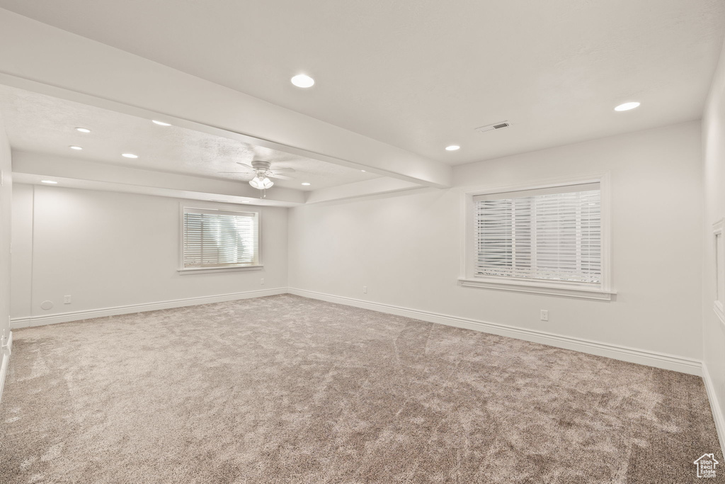 Carpeted spare room featuring ceiling fan