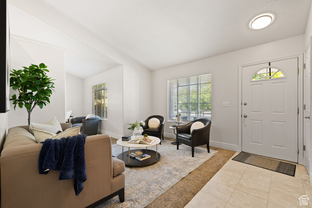 Living room with vaulted ceiling and light tile patterned floors