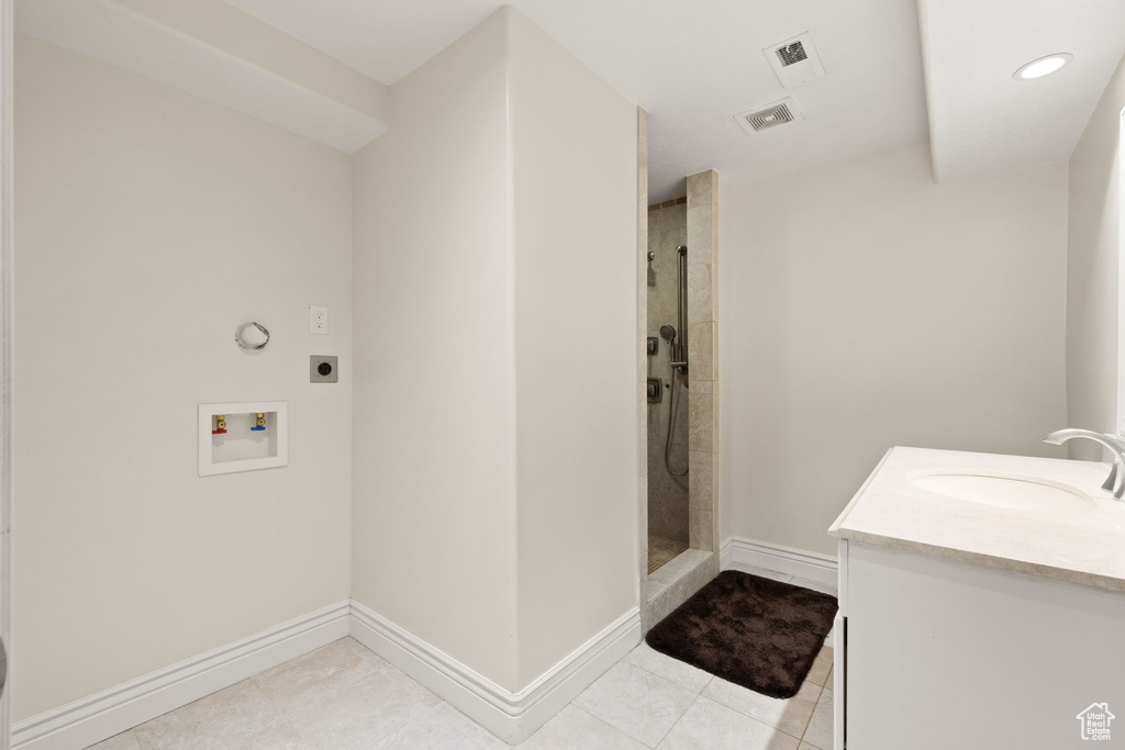 Interior space featuring vanity, tile patterned floors, and a tile shower