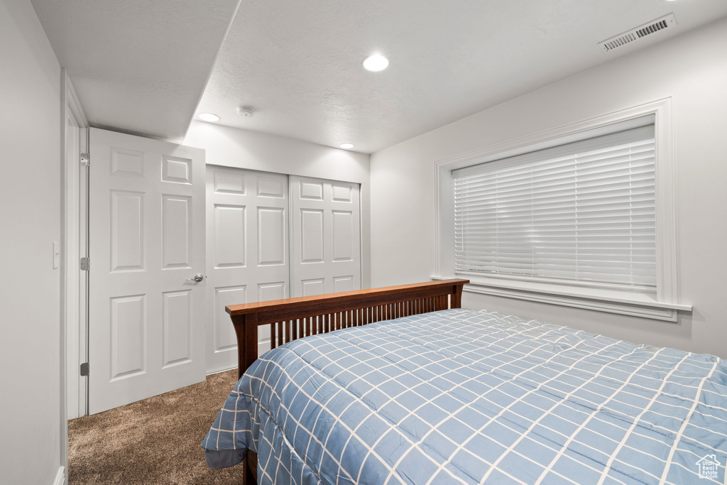 Carpeted bedroom with a closet