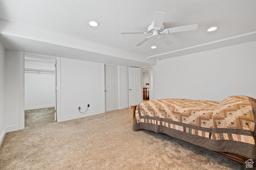 Carpeted bedroom with two closets and ceiling fan